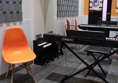 Salón de música con varios teclados y tratamiento acústico para clases grupales en MVS Music Center en CDMX, Querétaro, Estado de México y Los Cabos